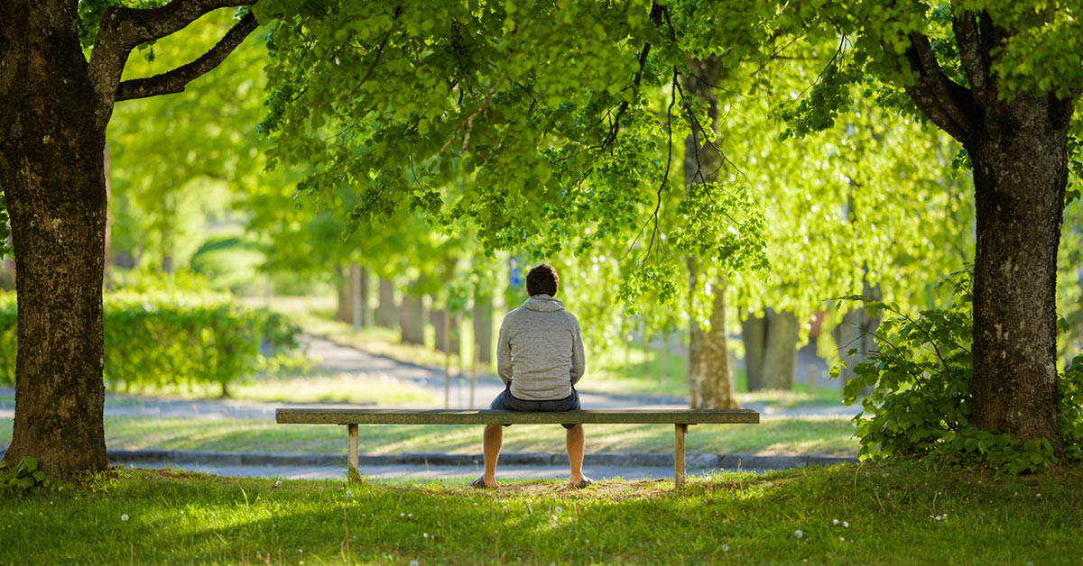 man sitting calmly in a park to clam down